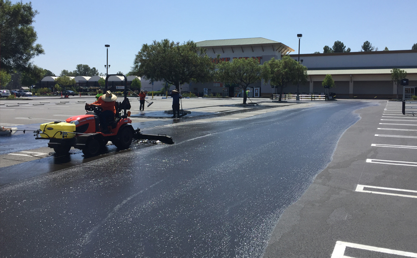 Worker striping parking lot pavement