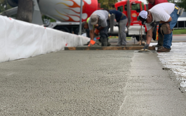 Team of workers leveling new pavement