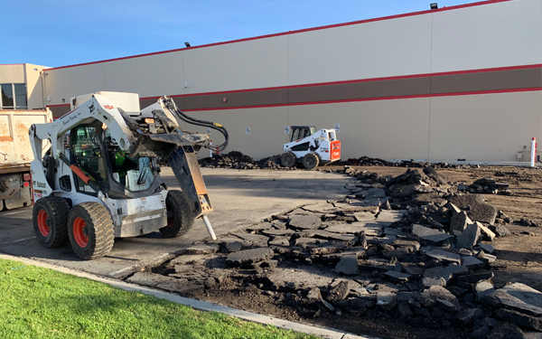 Worker driving and using constuction vehicle